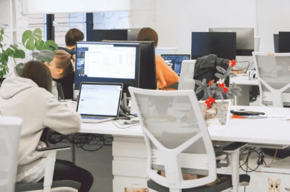 Employees working at computers in a modern open-plan office workspace