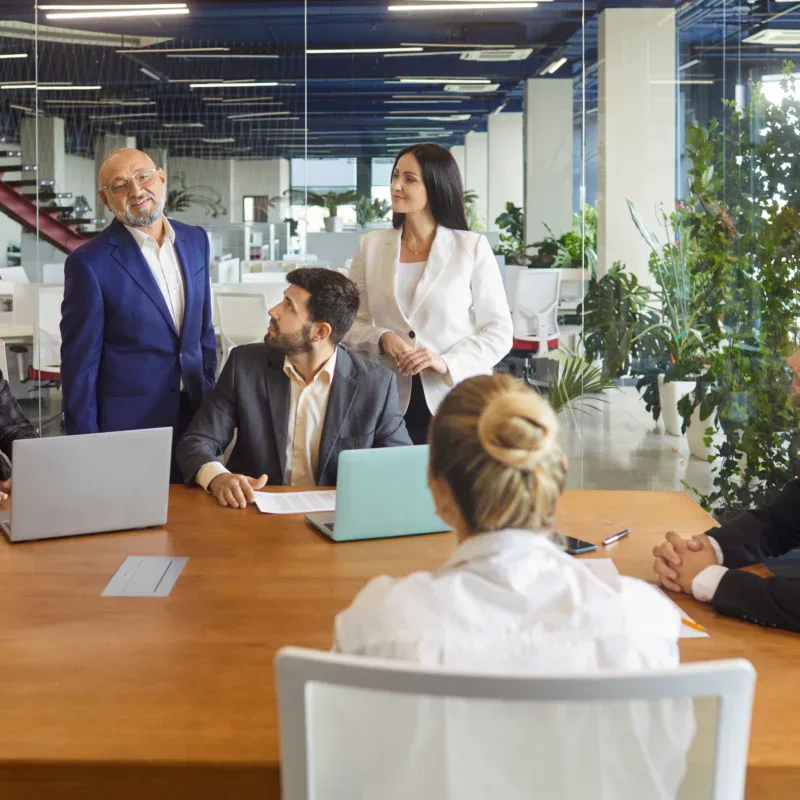 employees at conference table taking HR compliance training